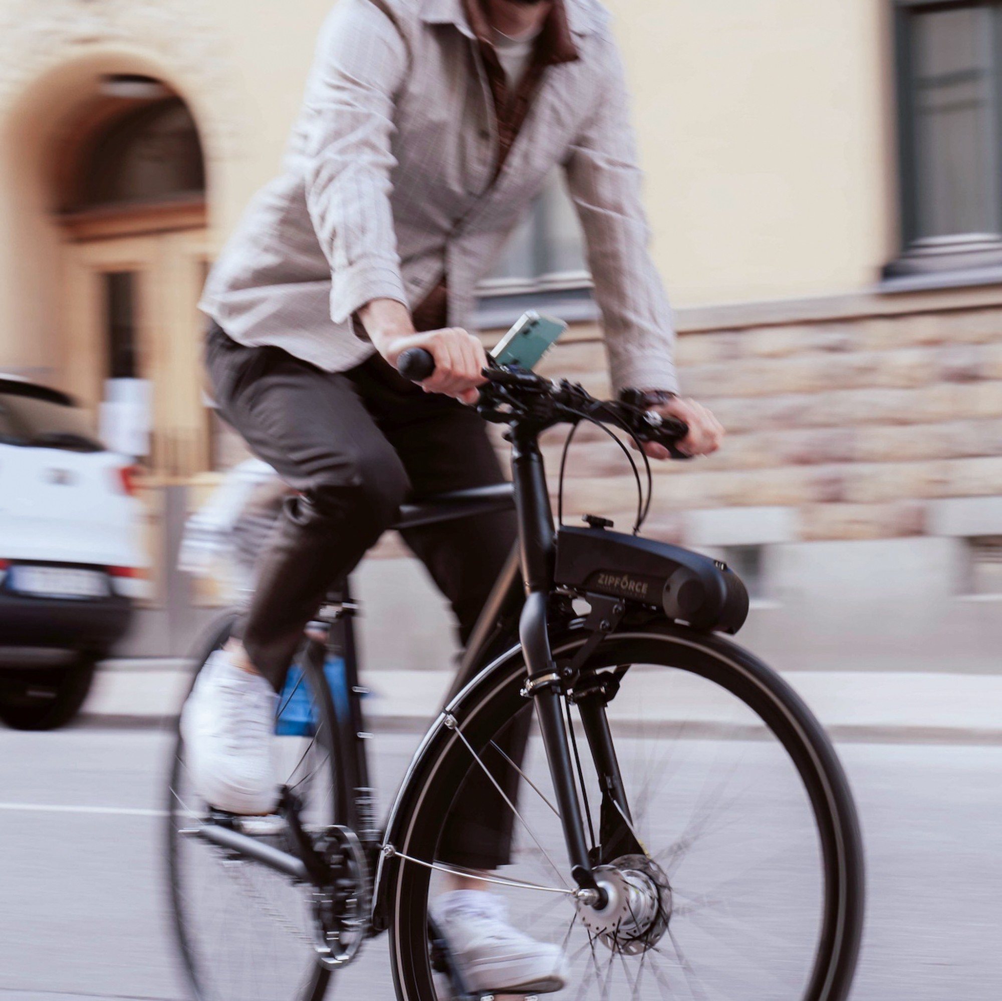 Rider on a city street with the Zipforce motor on the bike frame